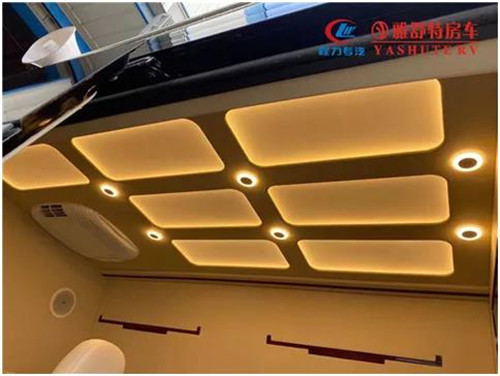 內(nèi)部車頂：采用帶造型的正白 LED 燈箱作為主照明系統(tǒng)，四角設(shè)計(jì)有帶獨(dú)立開關(guān)的裝飾射燈，嵌入式裝配工藝，便于后期檢修維護(hù)。車內(nèi)照明系統(tǒng)偏向于簡(jiǎn)潔、實(shí)用、明亮、整齊的現(xiàn)代辦公氛圍，LED 射燈指向光源和立柱壁燈，對(duì)整個(gè)辦公區(qū)照明，整車 內(nèi)部氛圍襯托均予以兼
